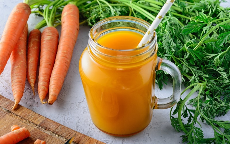 Beautiful composition with a jar of carrot juice and vegetables. Bright healthy smoothies. A useful veggie drink.